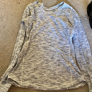 A lululemon long sleeve athletic shirt. It’s light grey and has strips on them.